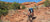 Athletic cyclist going down a rocky hillside in the desert.