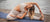 athletic woman stretching on a yoga mat on a dock near the water