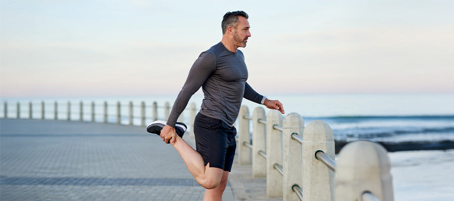 Man stretching at the beach after taking PerfectAmino