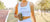 athletic woman at a track meet drinking PerfectAmino and Greens