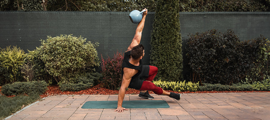 Athletic male working out with a kettle bell