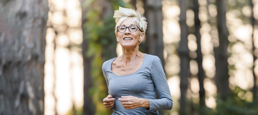 Older Athletic Female jogging in the woods