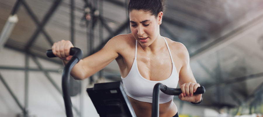 athletic woman working out on a stair climber at the gym