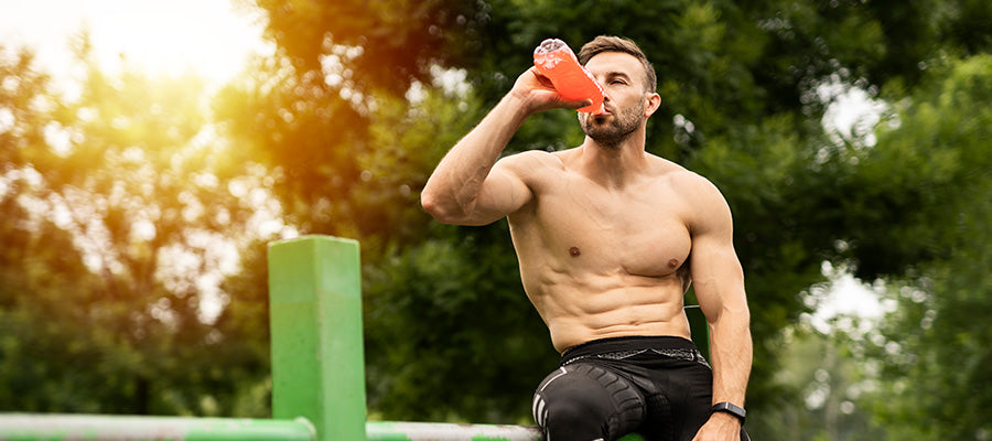 Athletic male resting and drinking BodyHealth Electrolytes after a workout.