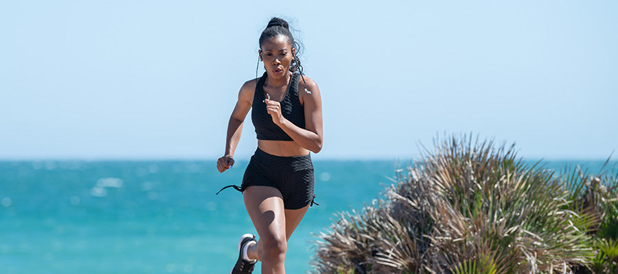 Athletic woman running on the beach.