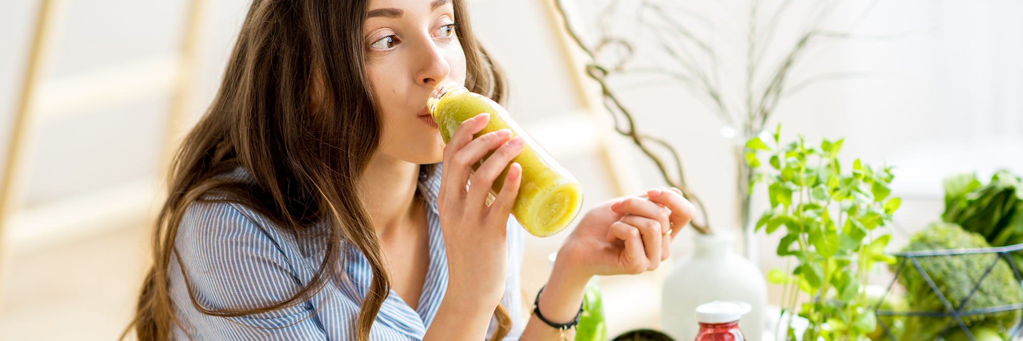 Healthy woman drinking a delicious bottle of Greens.