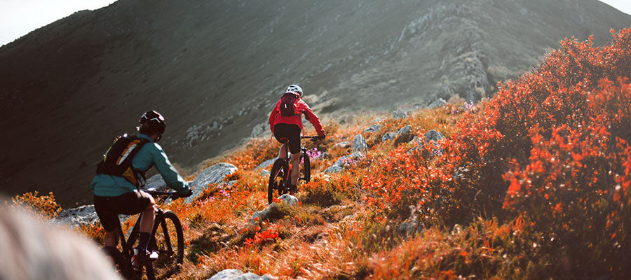 Pair of cyclist traversing a mountain side during autumn.