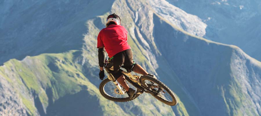 Mountain biker hitting a jump high in the mountains.