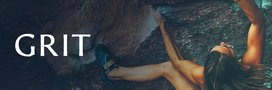 Athletic woman free climbing on a rock face.