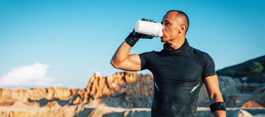 Athletic Male drinking PerfectAmino Powder after a run in the desert.