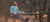Bearded man exercising on the parallel bars in the woods.