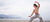 Athletic male doing Tai Chi on the beach near the water.