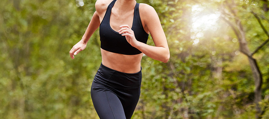 Athletic woman running in the woods.