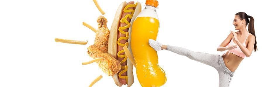 Woman kicking junk food like soft drinks and hotdogs.