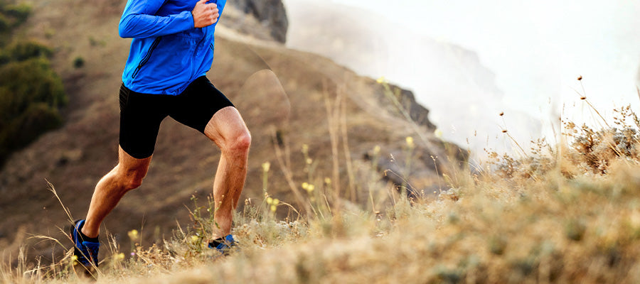 Athletic person running up a hill on a coast.