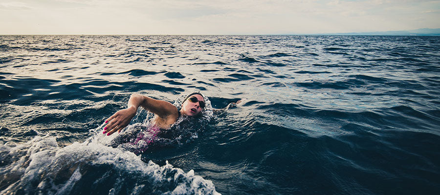 Athletic person swimming in a large body of water.