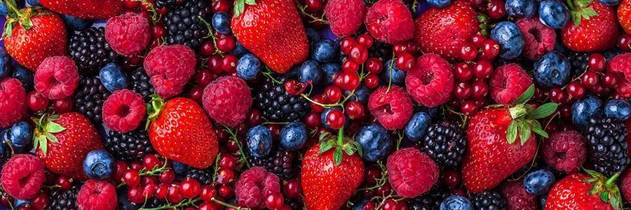 A pile of strawberries, blue berries, raspberries, and other berries.